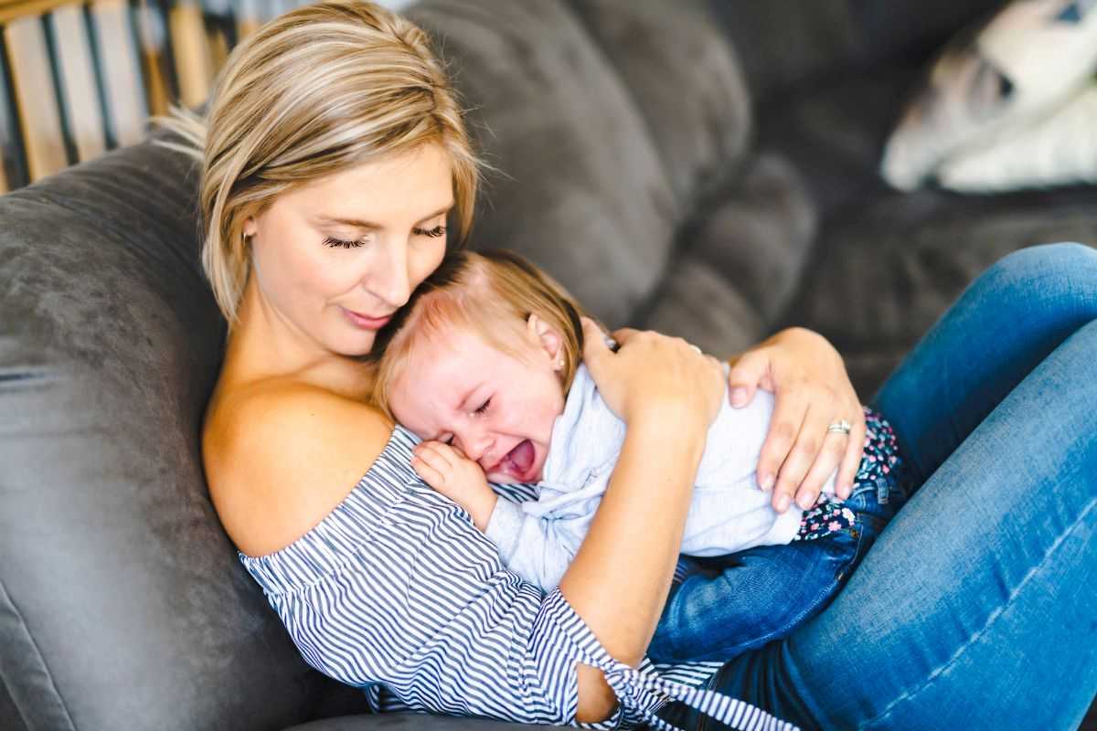 bambina che piange in braccio alla sua mamma