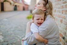 bimbo che piange in braccio alla mamma