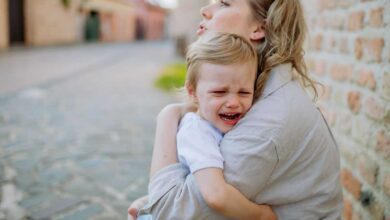 bimbo che piange in braccio alla mamma