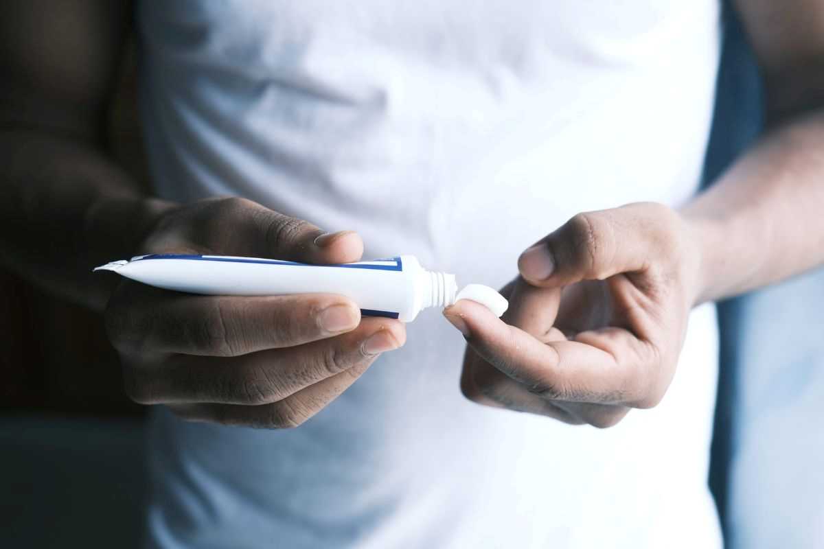 ragazzo applica una pomata al cortisone sulla pelle