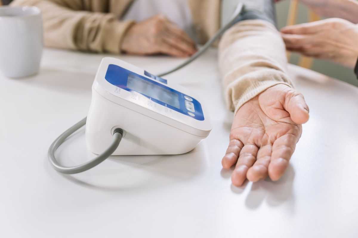 donna anziana che misura la pressione arteriosa a casa