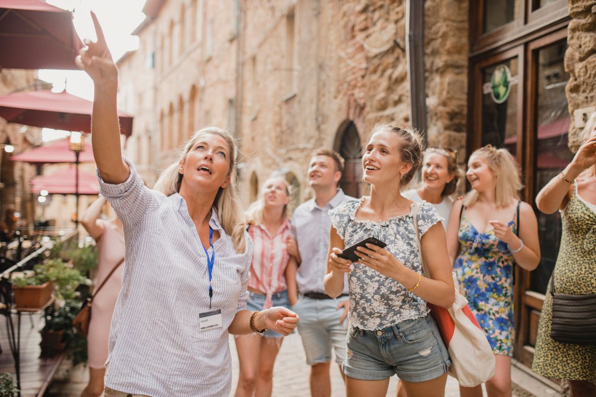 gruppo di persone che visita un borgo con la guida