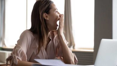 donna al lavoro che sbadiglia perché è in debito di sonno